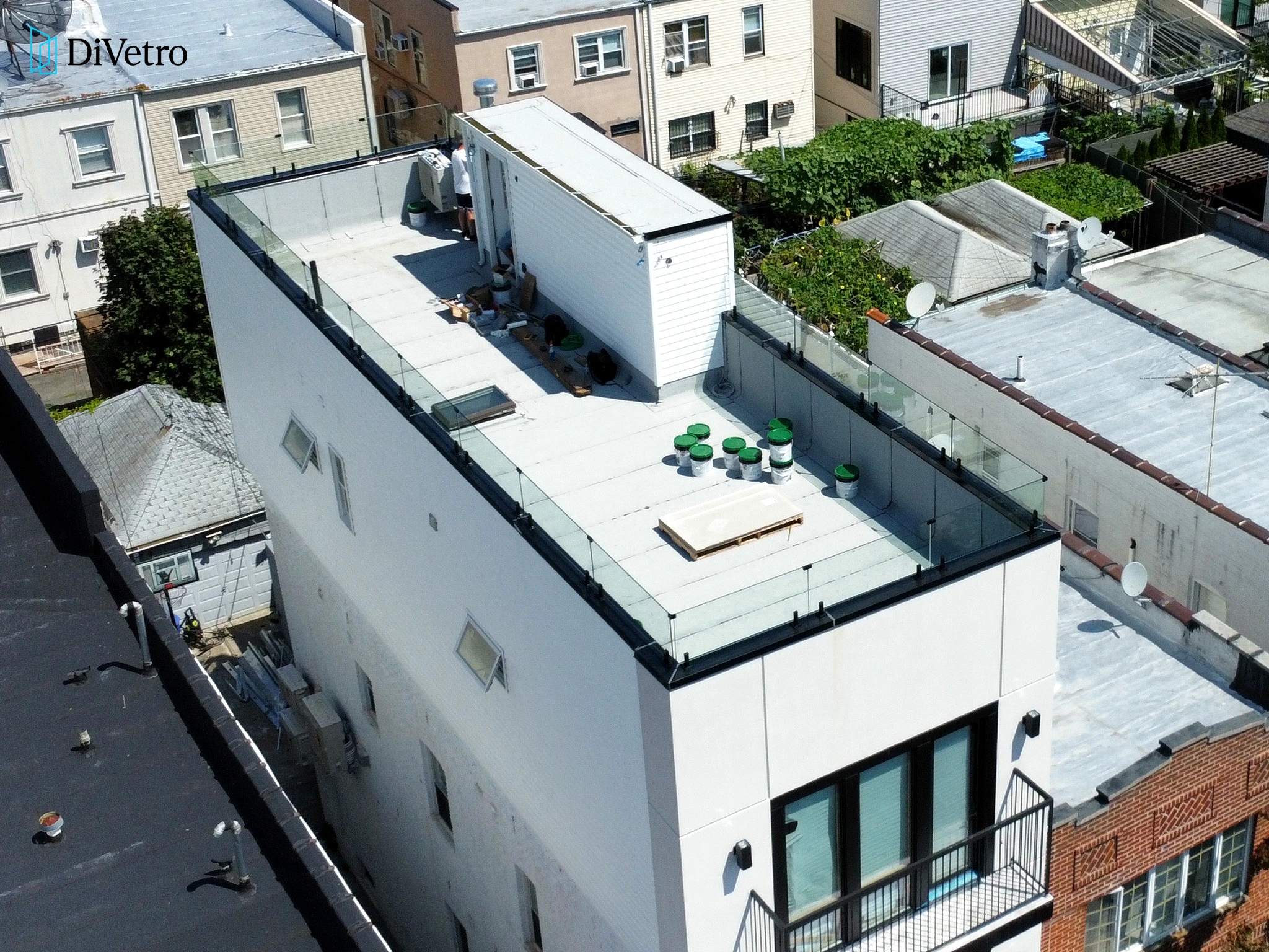 Real project — white-framed glass railings on a roof deck